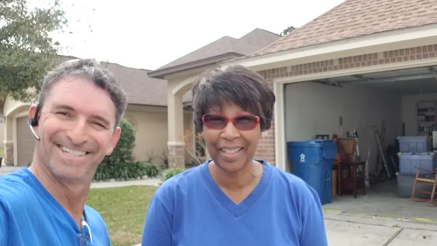 Smiling customer with her Moving Pro Inc mover outside her home