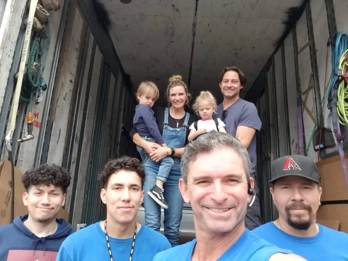 Parents and their two children in the truck with the whole Moving Pro Inc crew